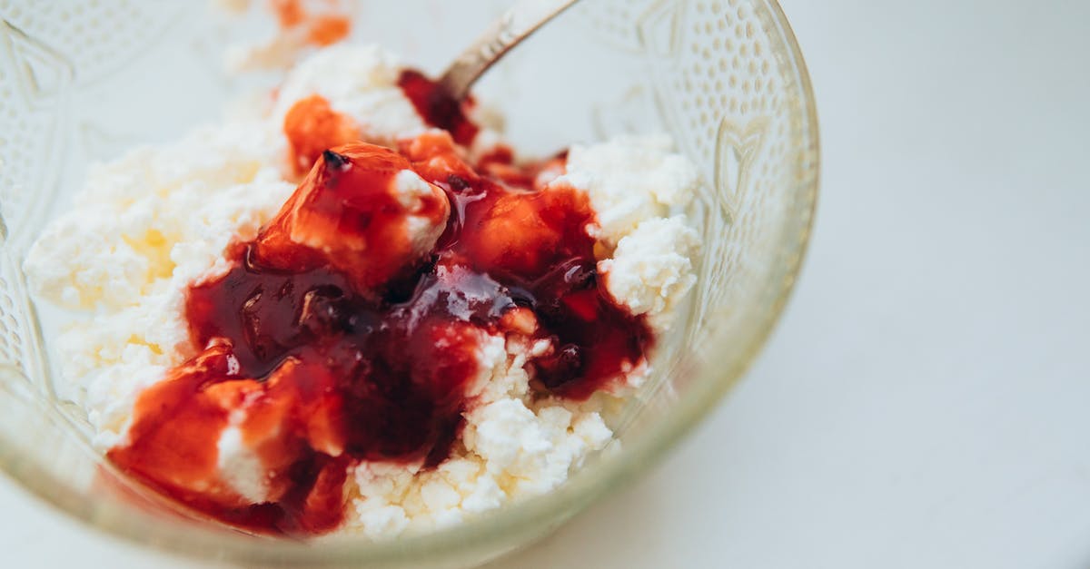 What causes yogurt in sauces to split? How to prevent it? - From above of appetizing cottage cheese with berry jam served in glass bowl with spoon on white table What causes yogurt in sauces to split? How to prevent it? - From above of appetizing cottage cheese with berry jam served in glass bowl with spoon on white table