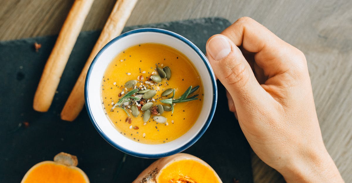 What characterizes a soup that holds well in a buffet setting? - Person Holding White Ceramic Bowl With Soup What characterizes a soup that holds well in a buffet setting? - Person Holding White Ceramic Bowl With Soup