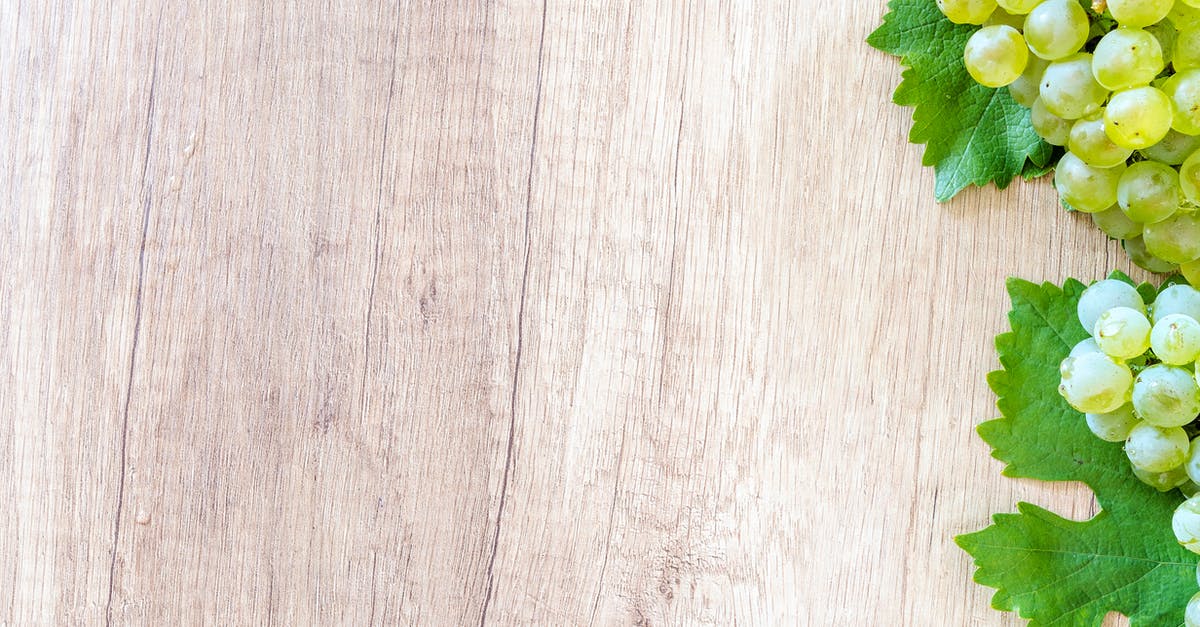 What color grapes are "Malaga grapes"? - Green Grapes on Brown Wooden Panel What color grapes are "Malaga grapes"? - Green Grapes on Brown Wooden Panel