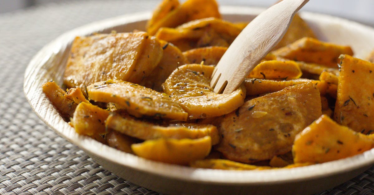 What determines sweet potato softness? - Closeup of bowl full of crispy baked sweet potatoes with herbs and eco friendly bamboo fork
