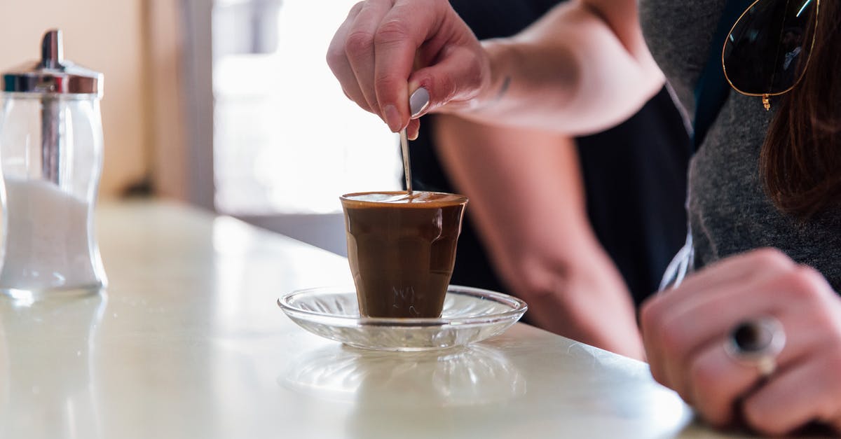 What direction must one stir molten chocolate? - Person Stiring Brown Liquid in Clear Drinking Glass What direction must one stir molten chocolate? - Person Stiring Brown Liquid in Clear Drinking Glass