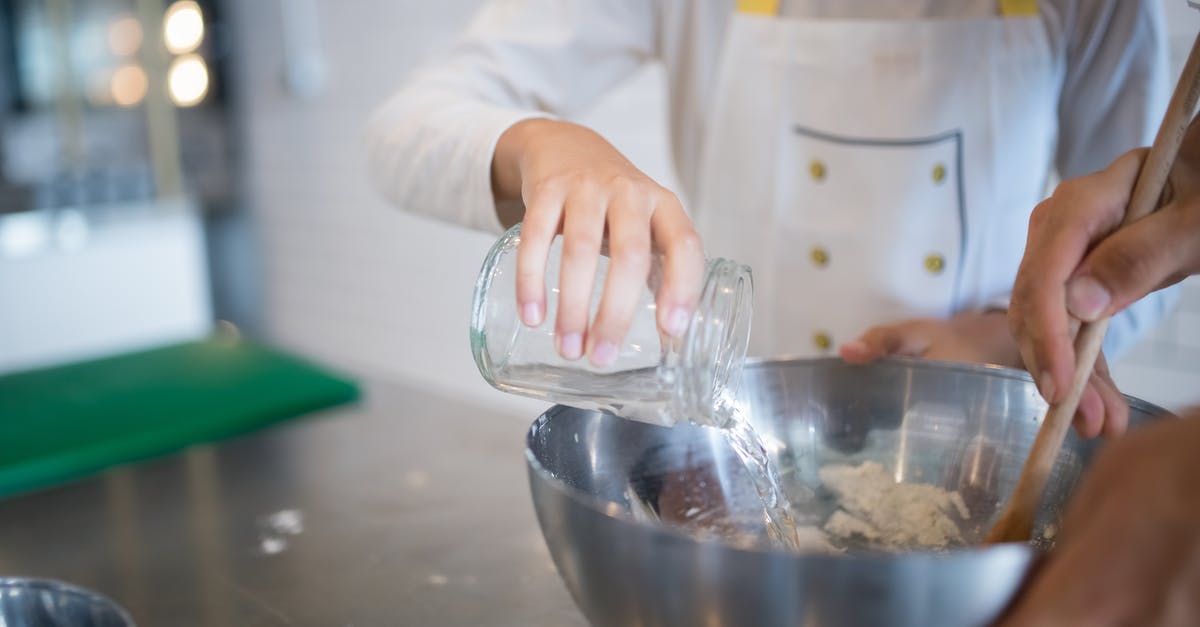 What does flushing mussels in water with flour do? - A Hand Pouring Water on the Stainless Bowl What does flushing mussels in water with flour do? - A Hand Pouring Water on the Stainless Bowl