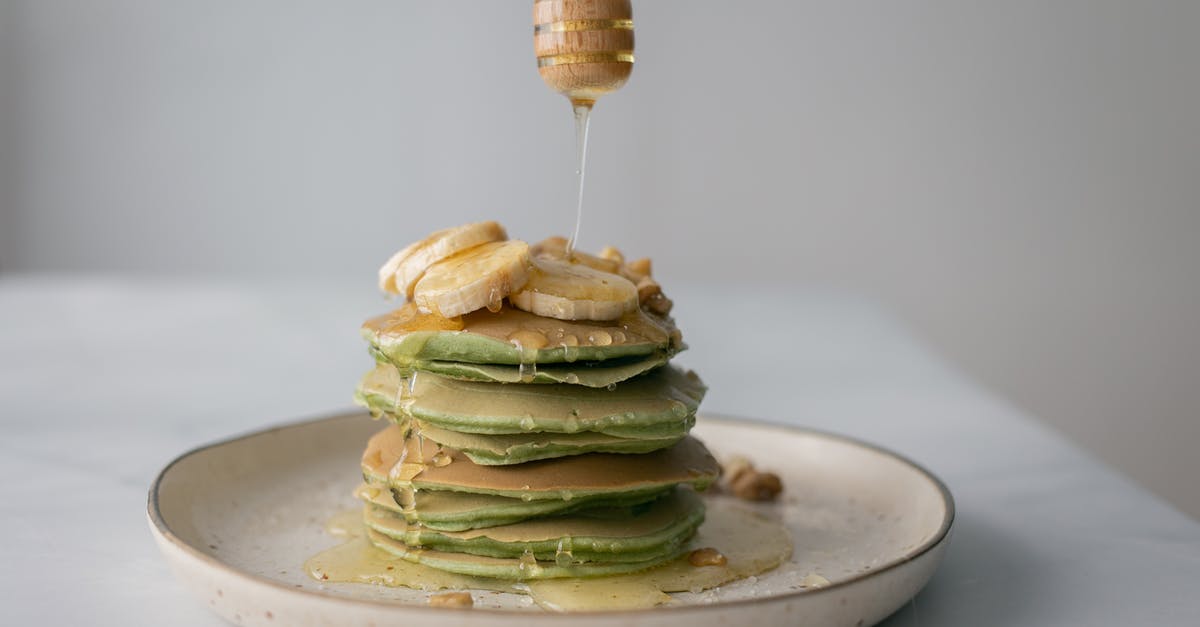 What does "buttermilk" mean in an American pancake recipe? - Tasty pancakes with fresh bananas served on plate and table on white blurred background What does "buttermilk" mean in an American pancake recipe? - Tasty pancakes with fresh bananas served on plate and table on white blurred background
