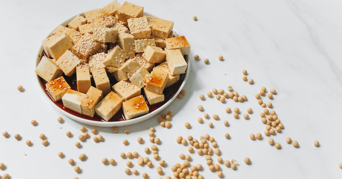 What does simmer slowly mean with white soybeans? - Sliced Tofu with Sesame Seeds on White Plate What does simmer slowly mean with white soybeans? - Sliced Tofu with Sesame Seeds on White Plate