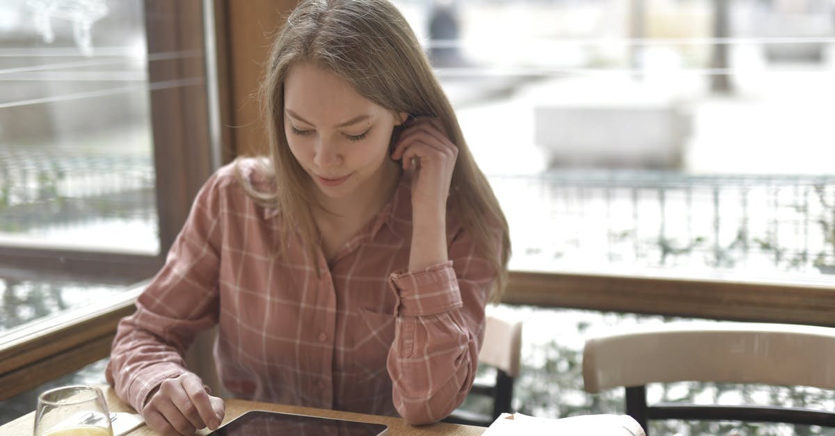 What effect does orange juice have when used in dough? - Cheerful concentrated female in checkered shirt sitting at table with glass of fresh juice and newspaper while using tablet What effect does orange juice have when used in dough? - Cheerful concentrated female in checkered shirt sitting at table with glass of fresh juice and newspaper while using tablet