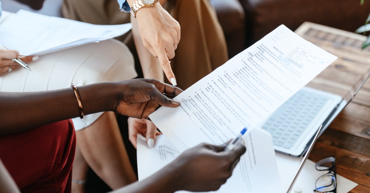 What features are important in a hand mixer? - Multiethnic businesswomen checking information in documents