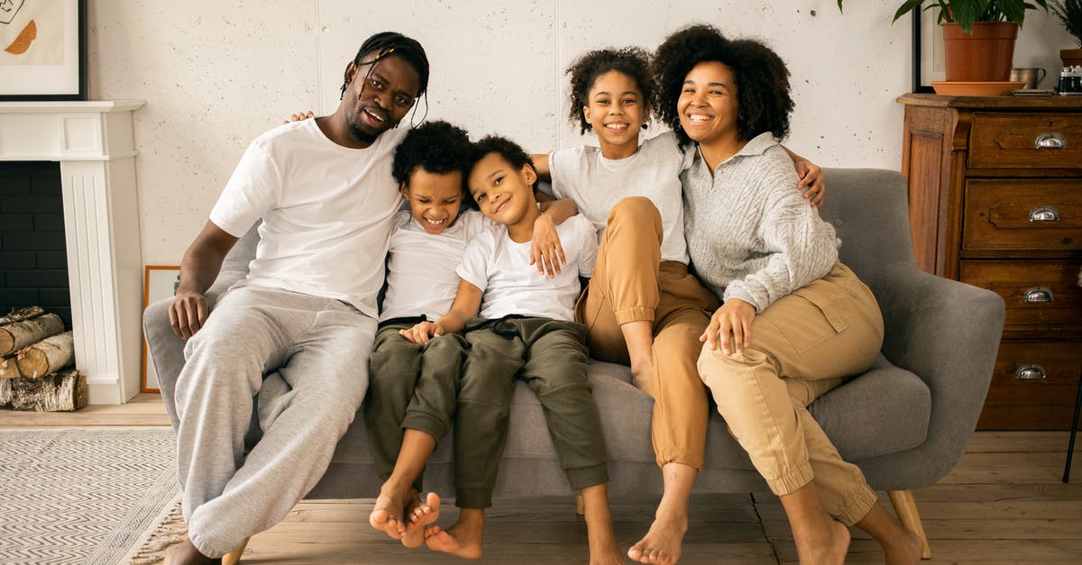 What features should I look for in a fireplace grill? - Full body of cheerful African American parents with children looking at camera while sitting on sofa in room with fireplace What features should I look for in a fireplace grill? - Full body of cheerful African American parents with children looking at camera while sitting on sofa in room with fireplace