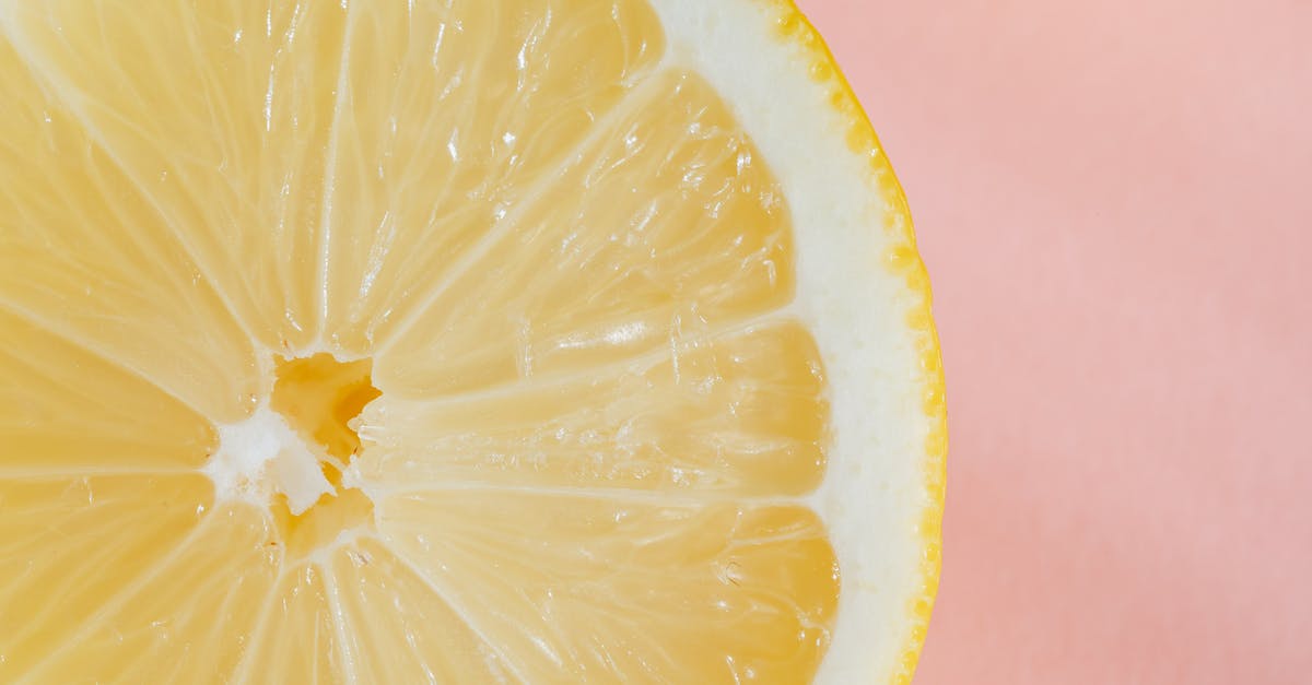 What flavorings do you use for sour pickles? - Closeup of slice of fresh juicy bright lemon placed on smooth pink surface What flavorings do you use for sour pickles? - Closeup of slice of fresh juicy bright lemon placed on smooth pink surface