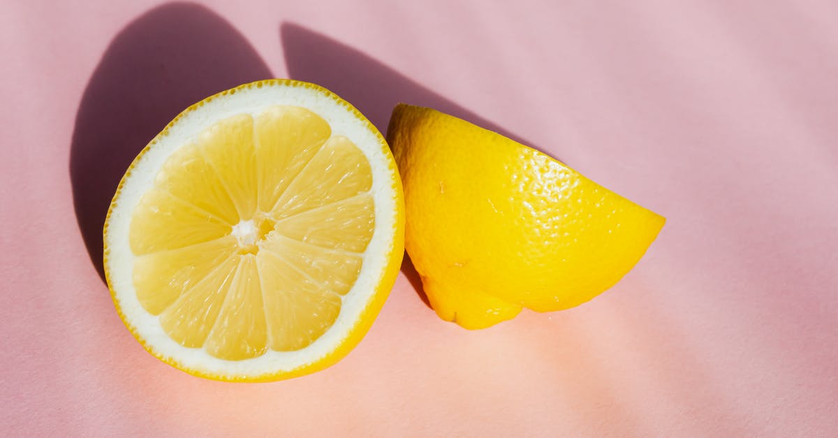 What flavorings do you use for sour pickles? - Top view of halves of fresh juicy lemon composed on pink background in sunbeams What flavorings do you use for sour pickles? - Top view of halves of fresh juicy lemon composed on pink background in sunbeams