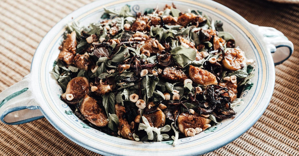 What gives arugula (wild rocket) its distinct taste? - Delicious healthy fig and arugula salad with cut nuts served on plate on table What gives arugula (wild rocket) its distinct taste? - Delicious healthy fig and arugula salad with cut nuts served on plate on table