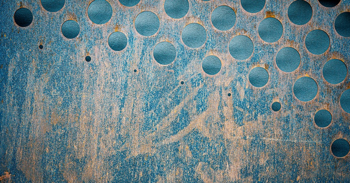 What hole size to prefer in the bread for what reasons? - Textured backdrop of blue metallic wall with scratches and rusty round shaped holes What hole size to prefer in the bread for what reasons? - Textured backdrop of blue metallic wall with scratches and rusty round shaped holes