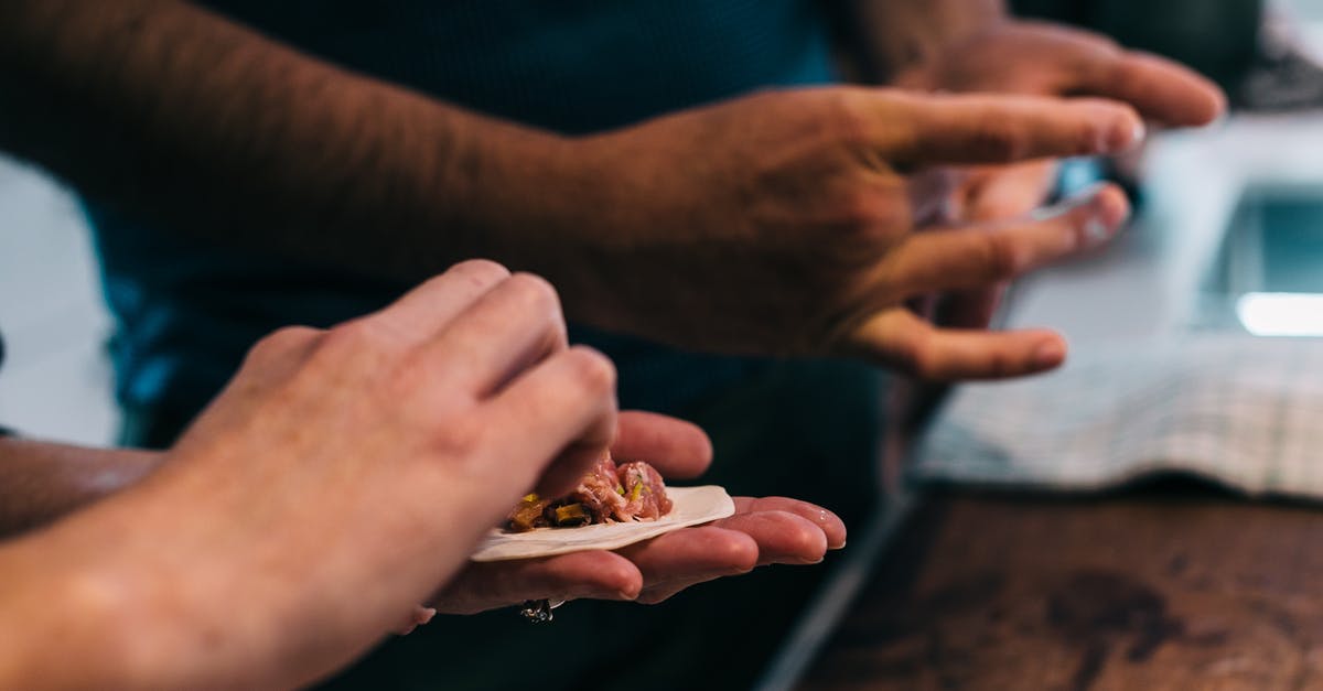 What ingredient, besides beans, creates a complete protein together with rice? - Crop cooks preparing dumplings at table in kitchen What ingredient, besides beans, creates a complete protein together with rice? - Crop cooks preparing dumplings at table in kitchen
