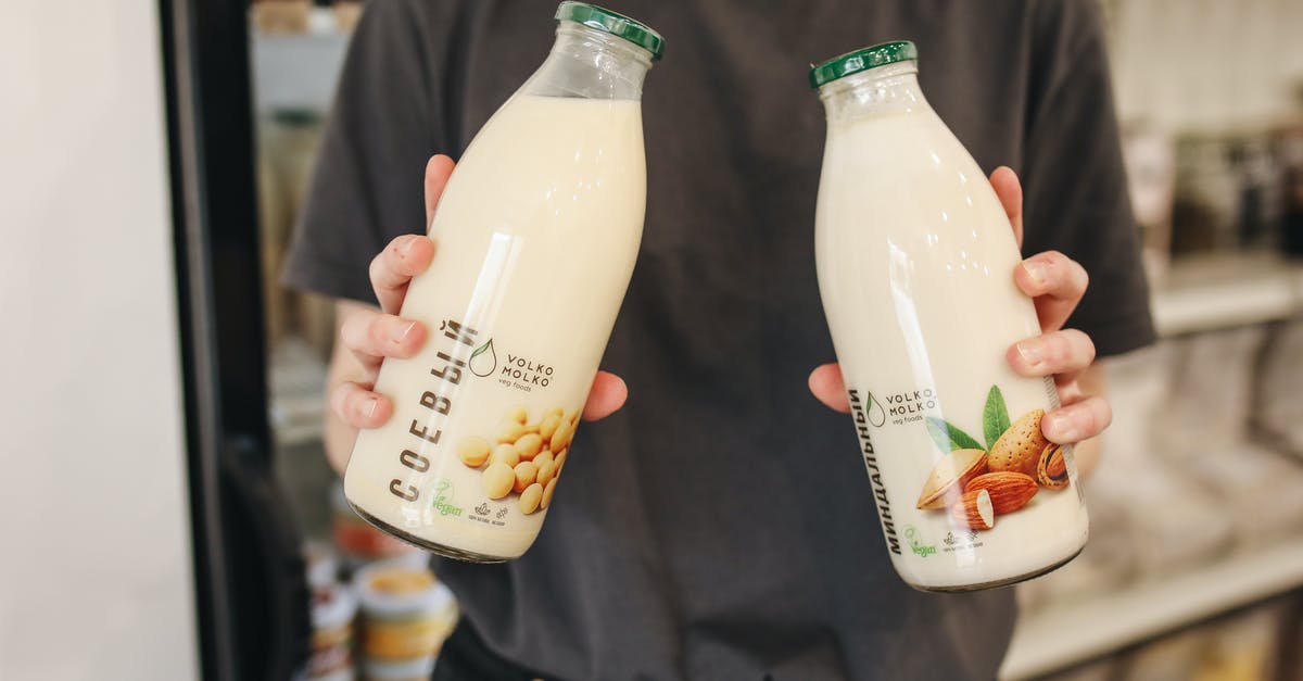 What is causing my homemade soy milk mayonnaise to have a different consistency than one made from store brought soy milk? - Person Holding Bottles with Milk