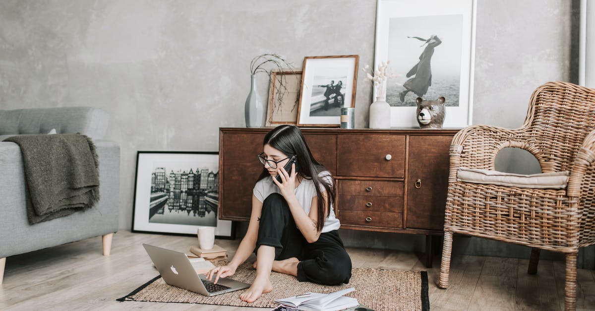 What is distilled or freeze-concentrated mead called? - Focused young woman with laptop and smartphone in modern apartment What is distilled or freeze-concentrated mead called? - Focused young woman with laptop and smartphone in modern apartment