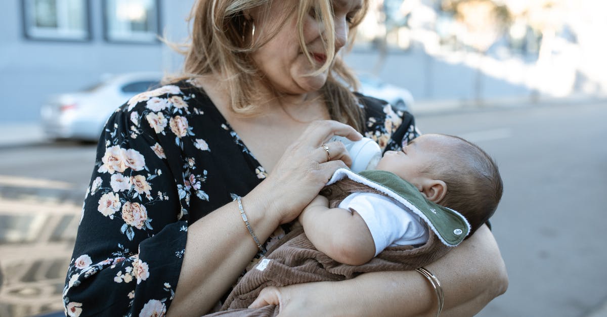 What is "reconstituted" milk? - A Mother Carrying Her Baby while Feeding Using a Milk Bottle