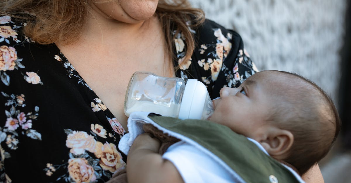 What is "reconstituted" milk? - A Woman in Floral Shirt Carrying a Baby while Drinking Milk