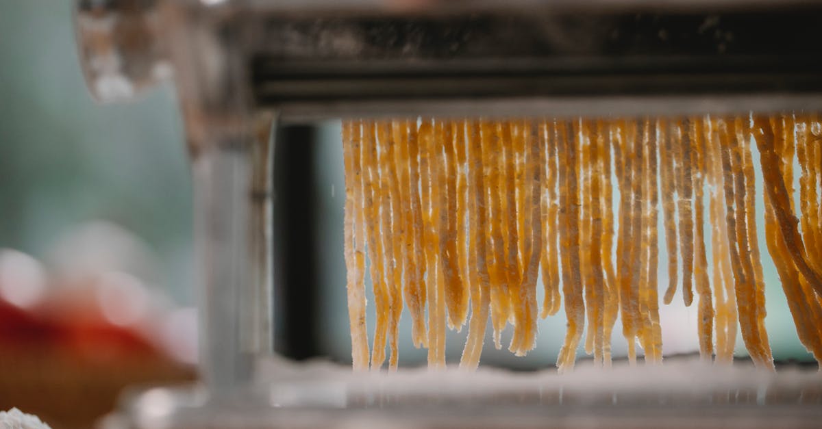 What is the authentic way to cook pierogi? - Process of cutting pasta with machine on kitchen
