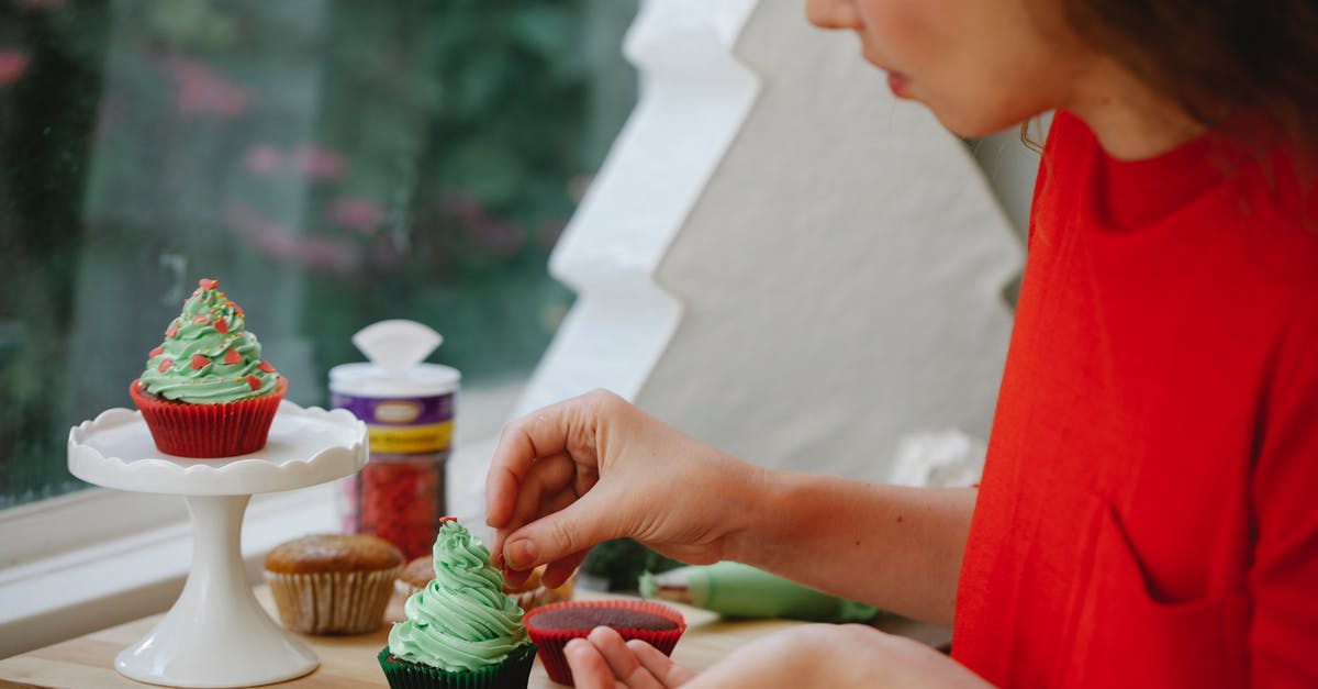 What is the best technique to put icing on plastic? - Side view of female cook putting sprinkles on frosting of cupcake while standing near window during holiday preparation at home What is the best technique to put icing on plastic? - Side view of female cook putting sprinkles on frosting of cupcake while standing near window during holiday preparation at home