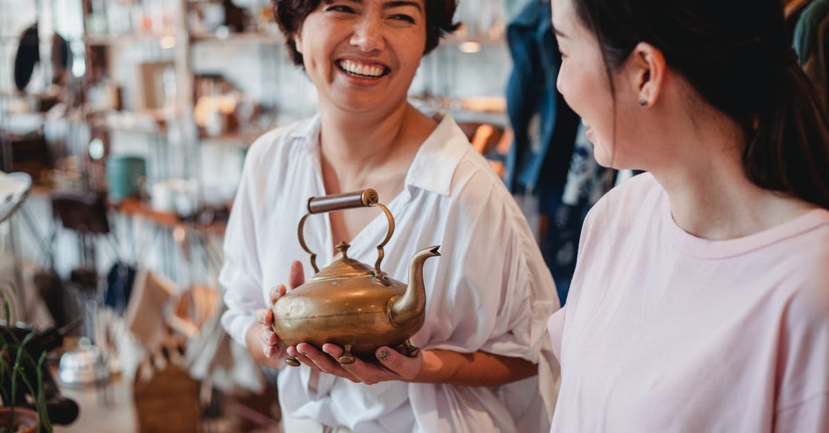 What is the best temperature to store honey at? - Crop cheerful ethnic female shoppers with oriental kettle speaking in local shop while spending time together and looking at each other What is the best temperature to store honey at? - Crop cheerful ethnic female shoppers with oriental kettle speaking in local shop while spending time together and looking at each other