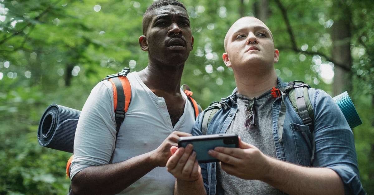 What is the best way to find a reliable pepper mill? - From below of diverse lost travelers with backpacks exploring woodland and searching way in cellphone