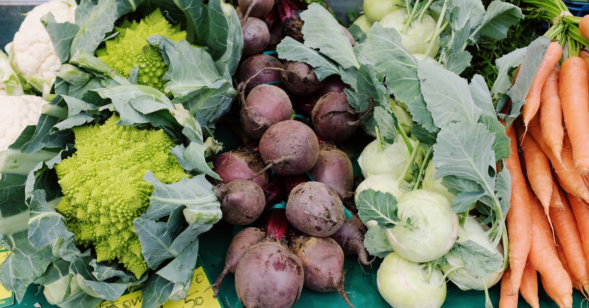 What is the best way to store prepared raw vegetables - From above set of fresh colorful vegetables placed on table with price tag in grocery market at daytime What is the best way to store prepared raw vegetables - From above set of fresh colorful vegetables placed on table with price tag in grocery market at daytime