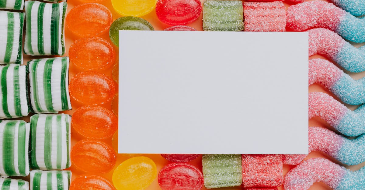 What is the difference between butterscotch, caramel, and toffee? - Top view closeup of blank paper card placed on multicolored various shapes yummy candies in light confectionery What is the difference between butterscotch, caramel, and toffee? - Top view closeup of blank paper card placed on multicolored various shapes yummy candies in light confectionery