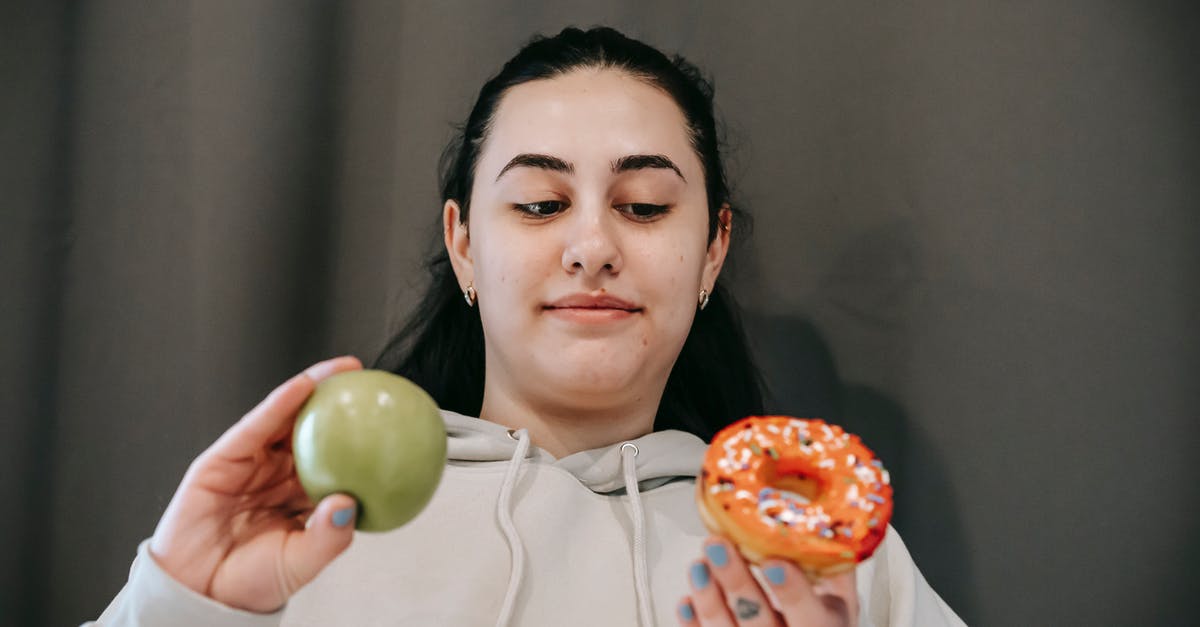 What is the difference between doughnut and krapfen? - Positive woman choosing between donut and apple What is the difference between doughnut and krapfen? - Positive woman choosing between donut and apple