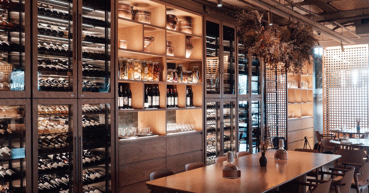 What is the difference between expensive wine and regular wine? - Wall with shelves with collection of assorted wine in modern restaurant with wooden furniture and creative decor What is the difference between expensive wine and regular wine? - Wall with shelves with collection of assorted wine in modern restaurant with wooden furniture and creative decor