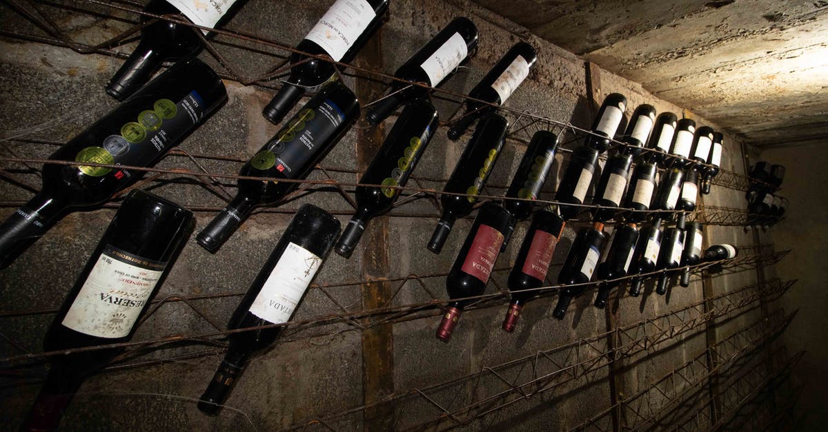 What is the difference between expensive wine and regular wine? - Rows of glass bottles filled with various wine in cellar with gray concrete walls What is the difference between expensive wine and regular wine? - Rows of glass bottles filled with various wine in cellar with gray concrete walls