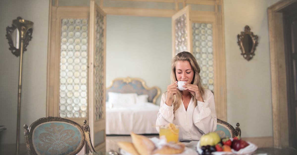 What is the difference between expensive wine and regular wine? - Glad female in elegant wear sitting at table with metal tray of healthy breakfast in vintage hotel room and drinking coffee in morning What is the difference between expensive wine and regular wine? - Glad female in elegant wear sitting at table with metal tray of healthy breakfast in vintage hotel room and drinking coffee in morning