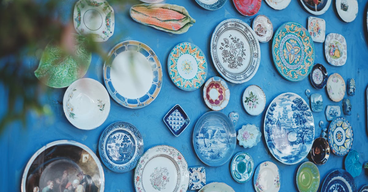What is the difference between these tableware flatware and cutlery? - Collection of various ceramic plates of different sizes and ornaments arranged on bright blue wall in studio What is the difference between these tableware flatware and cutlery? - Collection of various ceramic plates of different sizes and ornaments arranged on bright blue wall in studio