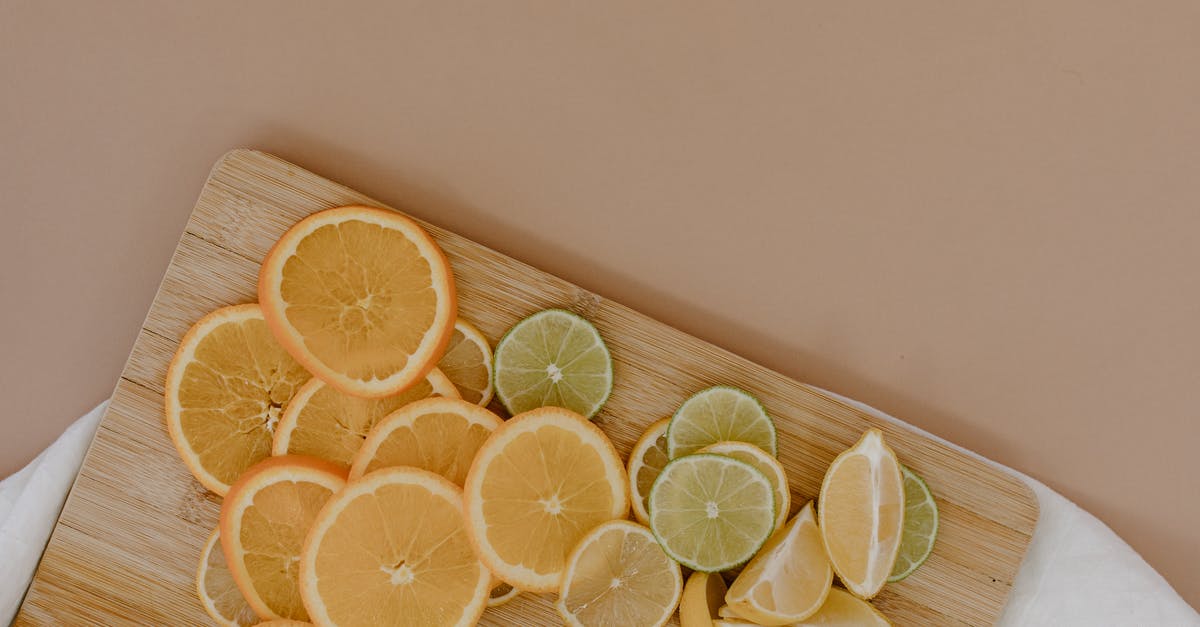What is the difference between white and green asparagus? - Top view of sliced with yellow lemons near oranges and green limes on wooden cutting board on white napkin on beige surface in light place What is the difference between white and green asparagus? - Top view of sliced with yellow lemons near oranges and green limes on wooden cutting board on white napkin on beige surface in light place