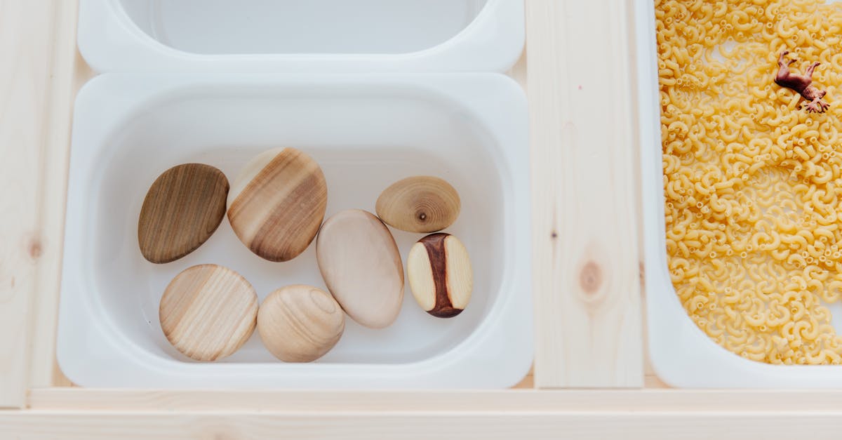 What is the difference using plastic or bronze mould for pasta maker? - Set of plastic containers with various stones and raw pasta on table