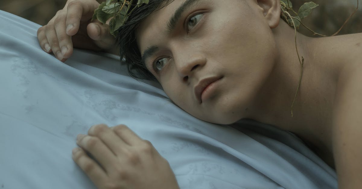 What is the history of the standard sheet (bun) pan? - Ethnic tanned male in green wreath lying on white sheet and looking away What is the history of the standard sheet (bun) pan? - Ethnic tanned male in green wreath lying on white sheet and looking away