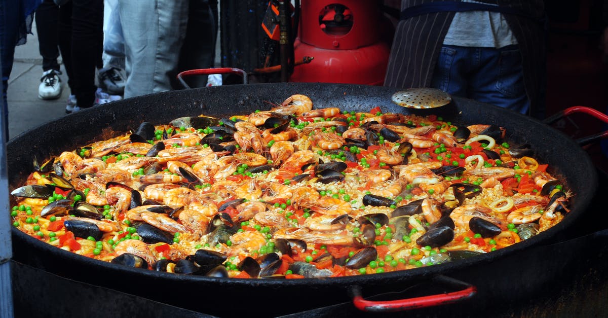 What is the ingredient that makes a Spanish paella so particular? - From above of traditional tasty Spanish dish with rice and bright chopped vegetables decorated with shellfish What is the ingredient that makes a Spanish paella so particular? - From above of traditional tasty Spanish dish with rice and bright chopped vegetables decorated with shellfish