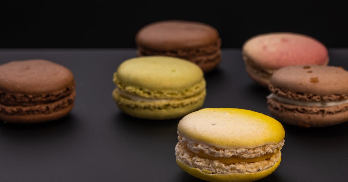 What is the name for a round flaky pastry that has a chocolate cream filling in the middle - High angle soft focus of yummy yellow macaron placed on black table in studio What is the name for a round flaky pastry that has a chocolate cream filling in the middle - High angle soft focus of yummy yellow macaron placed on black table in studio