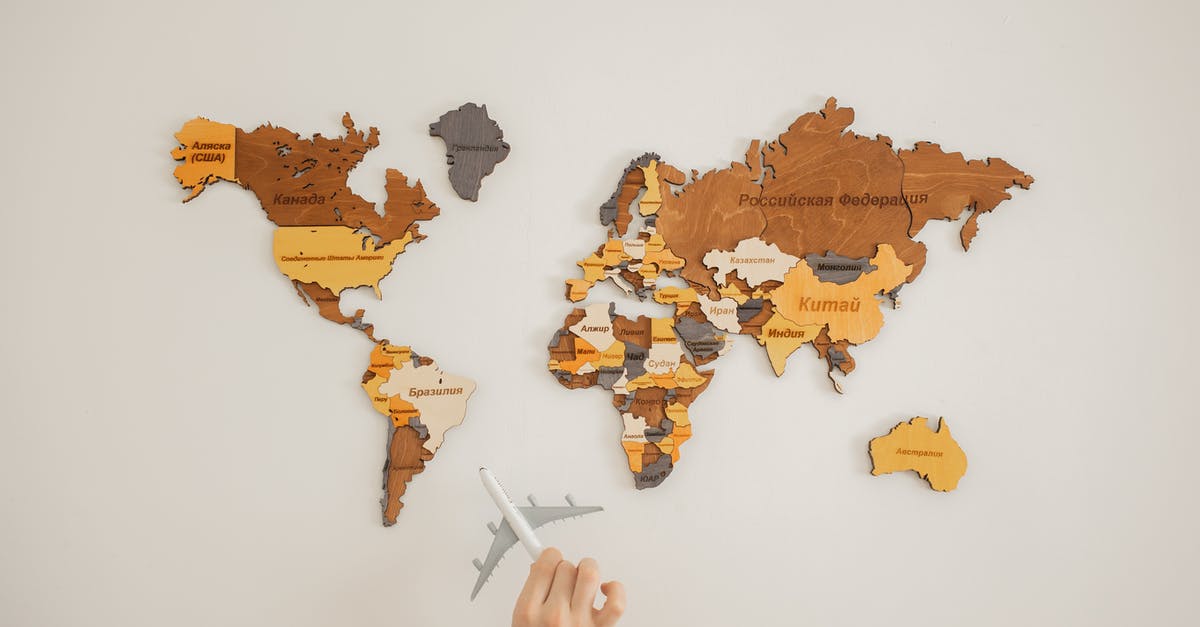 What is the name of this Turkish chocolate? - Crop unrecognizable person with toy aircraft near multicolored decorative world map with continents attached on white background in light studio What is the name of this Turkish chocolate? - Crop unrecognizable person with toy aircraft near multicolored decorative world map with continents attached on white background in light studio