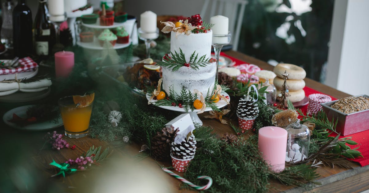 What is the New Zealand white sponge cake, is it a white cake here in the U.S? - Festive cake with pomegranate and physalis and desserts served on table with Christmas candles and fir branches