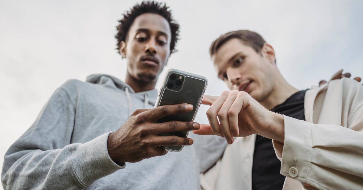 What is the point of a "Friendship Bread" starter? - Multiethnic friends browsing smartphone together outside