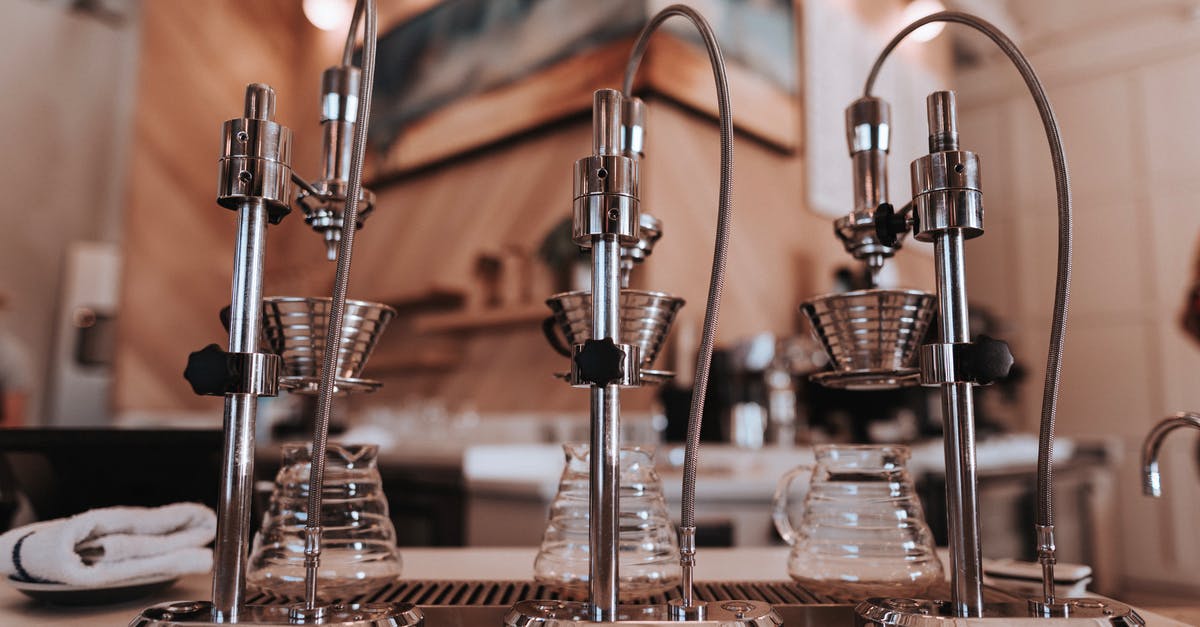 What is the preferred method for sanitizing the kitchen? - Stainless steel similar drip coffee machine with ribbed filters and transparent glass carafes on table near towel in apartment with artificial light What is the preferred method for sanitizing the kitchen? - Stainless steel similar drip coffee machine with ribbed filters and transparent glass carafes on table near towel in apartment with artificial light