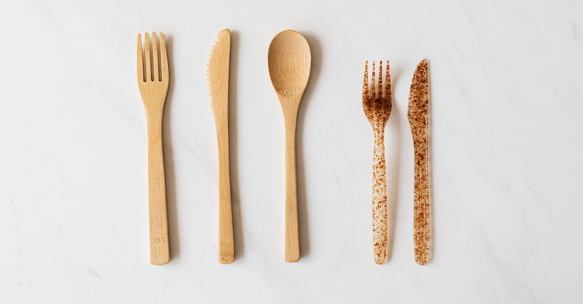 What is the proper way to dispose of a kitchen knife? - Top view of wooden and plastic cutlery placed in row on white marble table What is the proper way to dispose of a kitchen knife? - Top view of wooden and plastic cutlery placed in row on white marble table