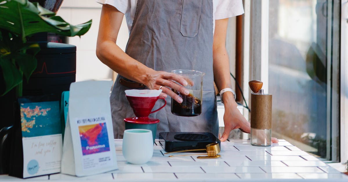 What is the proper way to make a cup of mate? - Woman in apron preparing coffee in cafe What is the proper way to make a cup of mate? - Woman in apron preparing coffee in cafe