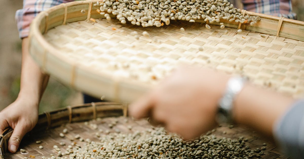What is the purpose of sifting dry ingredients? - Crop unrecognizable horticulturists with sieves separating unroasted coffee bean halves from chaff in countryside in daylight