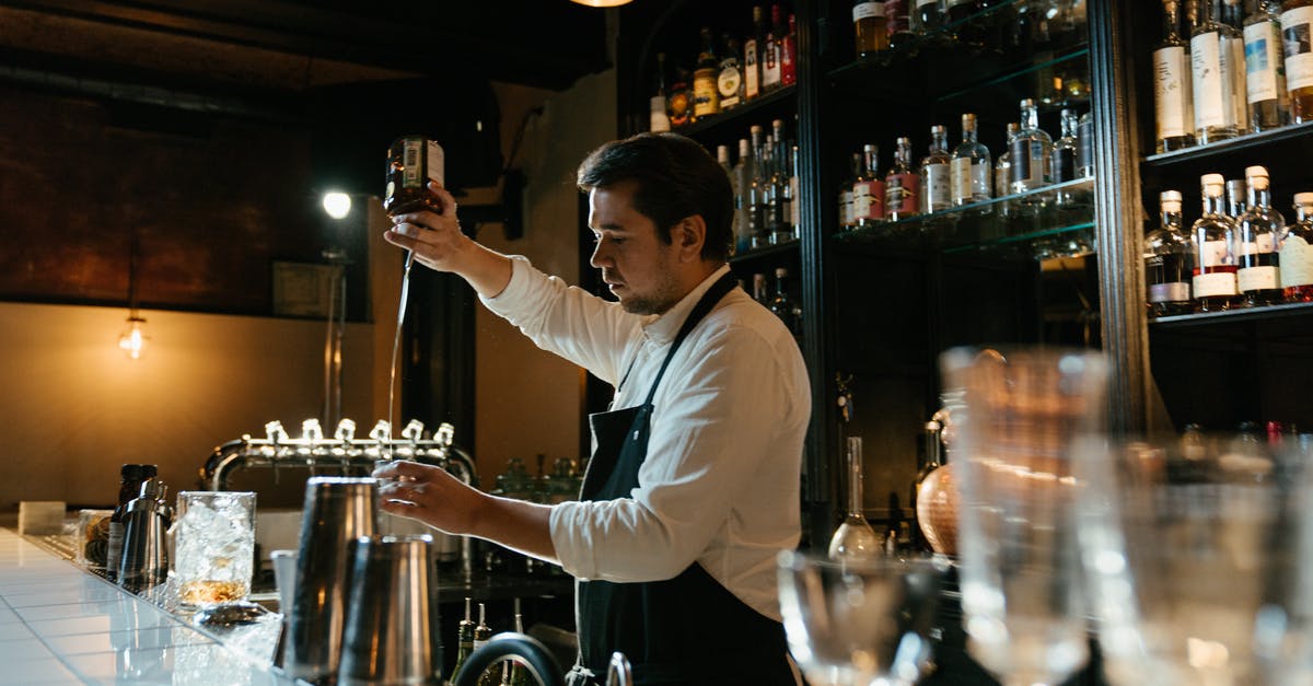 What is the secret behind "always soft" ice cream? - Man in White Long Sleeve Shirt Pouring Wine on Clear Wine Glass