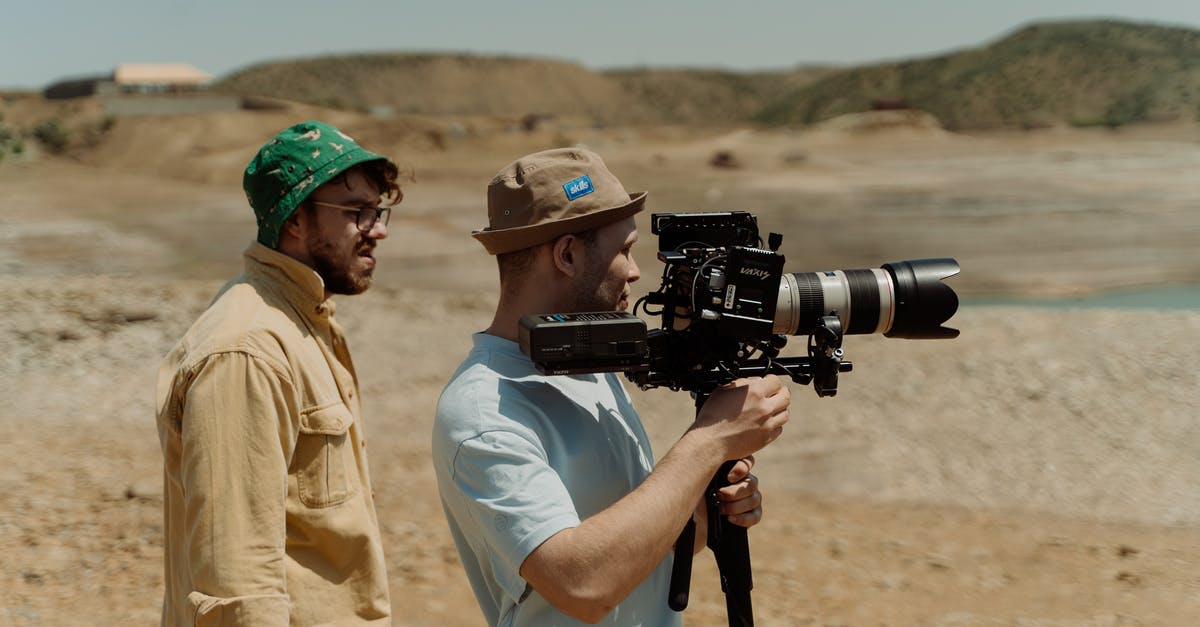 What is the thin, colorless film that remains after making oatmeal? - A Man in Brown Bucket Hat Holding a Video Camera while Standing Beside the Man in Green Bucket Hat What is the thin, colorless film that remains after making oatmeal? - A Man in Brown Bucket Hat Holding a Video Camera while Standing Beside the Man in Green Bucket Hat