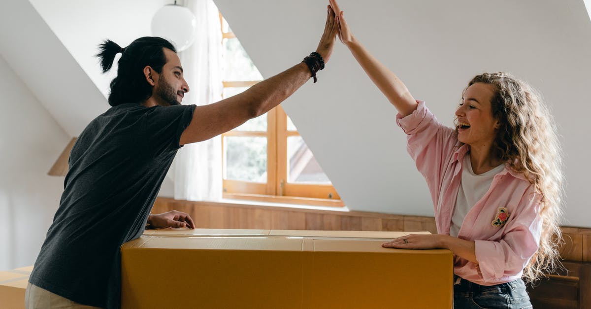 What is this beanlike thing? - Exited diverse couple relocating in new apartment What is this beanlike thing? - Exited diverse couple relocating in new apartment