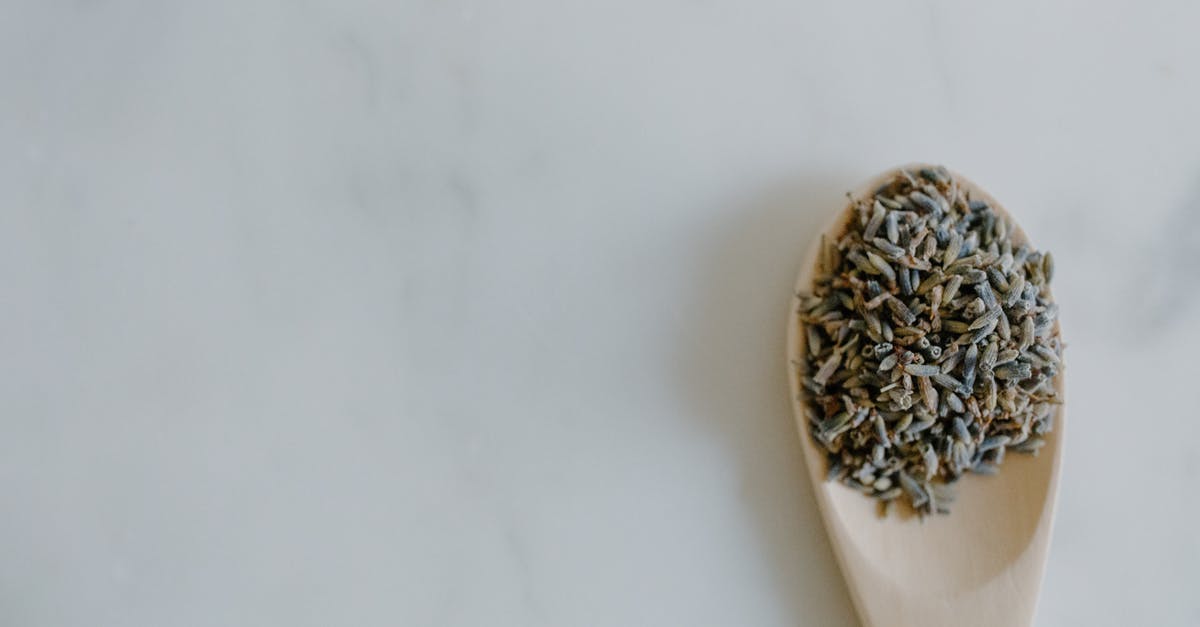 What is this distinctive smell in some dry cured sausage? - Top view of dried lavender in spoon placed on white marble surface in light room What is this distinctive smell in some dry cured sausage? - Top view of dried lavender in spoon placed on white marble surface in light room