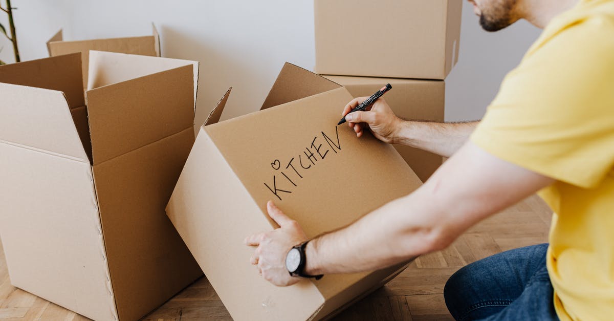 What is this yellow "fat" thing on my bacon - Crop man with pile of cardboard boxes for packing belongings What is this yellow "fat" thing on my bacon - Crop man with pile of cardboard boxes for packing belongings