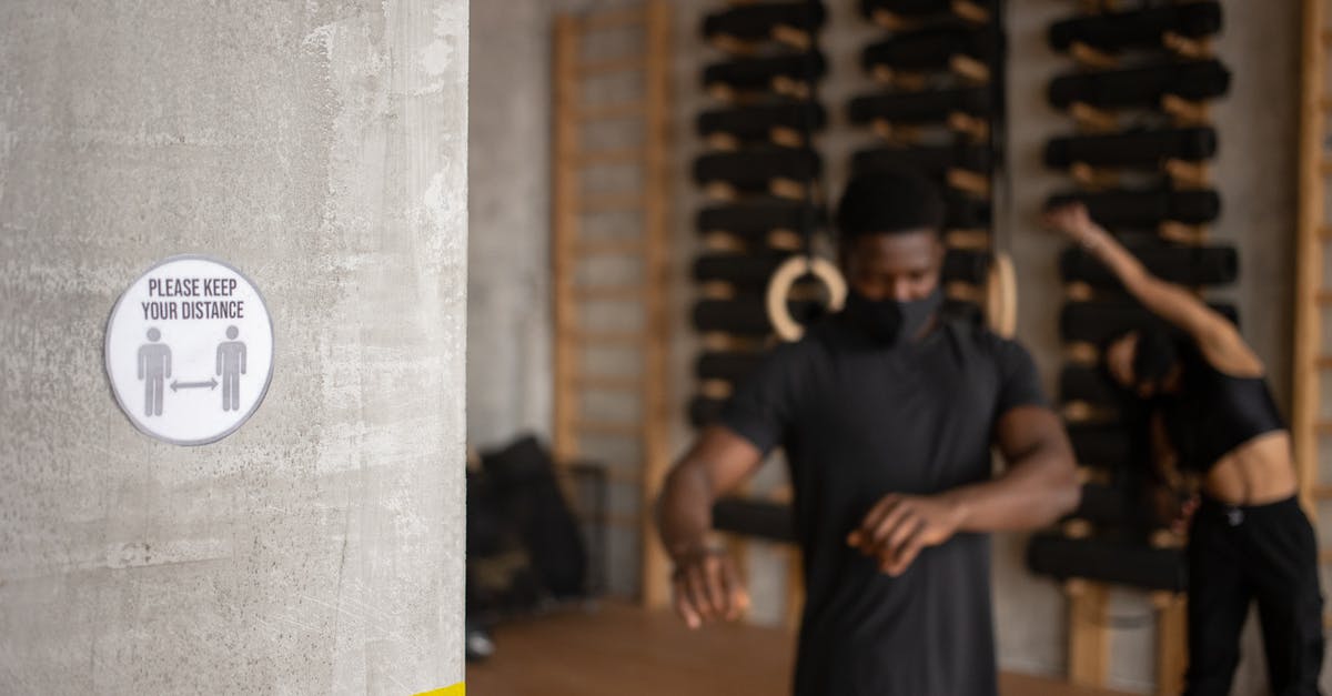 What is your training regimen for developing your palate? - Title on sign with figures and arrows showing distance against anonymous ethnic athletes in face masks during training in gym What is your training regimen for developing your palate? - Title on sign with figures and arrows showing distance against anonymous ethnic athletes in face masks during training in gym