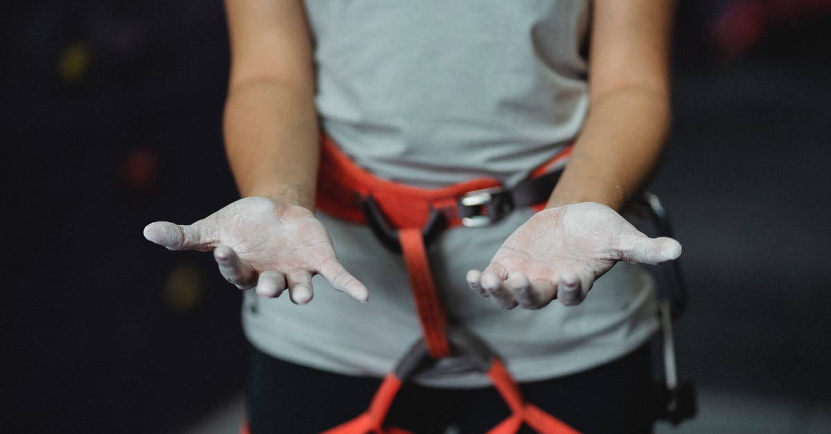 What kind of equipment do I need to turn dried chilli flakes into powder? - Crop anonymous slender female alpinist with safety harness demonstrating hands in talcum powder before practice